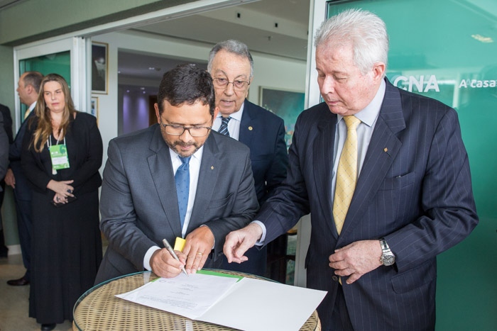 João Rabelo, vice-presidente do BB (à esquerda) e Rubem Novaes, presidente do Banco (à direita) assinam documento da parceria.