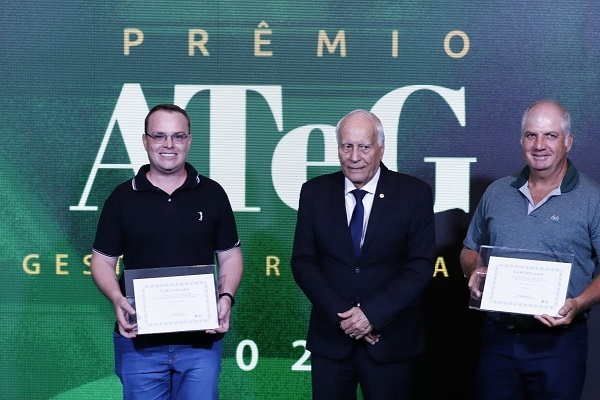 Produtor Gleder Luiz e o técnico de campo Leandro Fachi recebem certificado do presidente da Faes, Júlio Rocha.